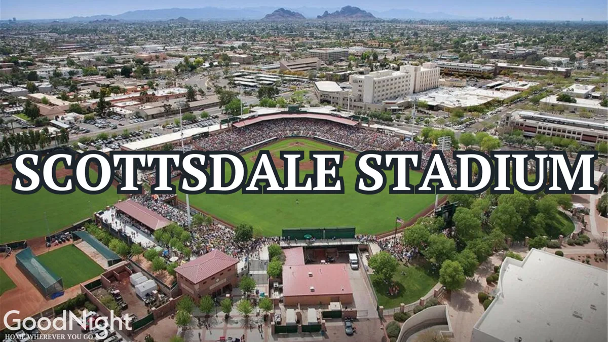 A bustling baseball stadium filled with fans, showcasing the lively atmosphere during a game. The scene includes the baseball field, stadium architecture, and the surrounding landscape, all bathed in daylight.